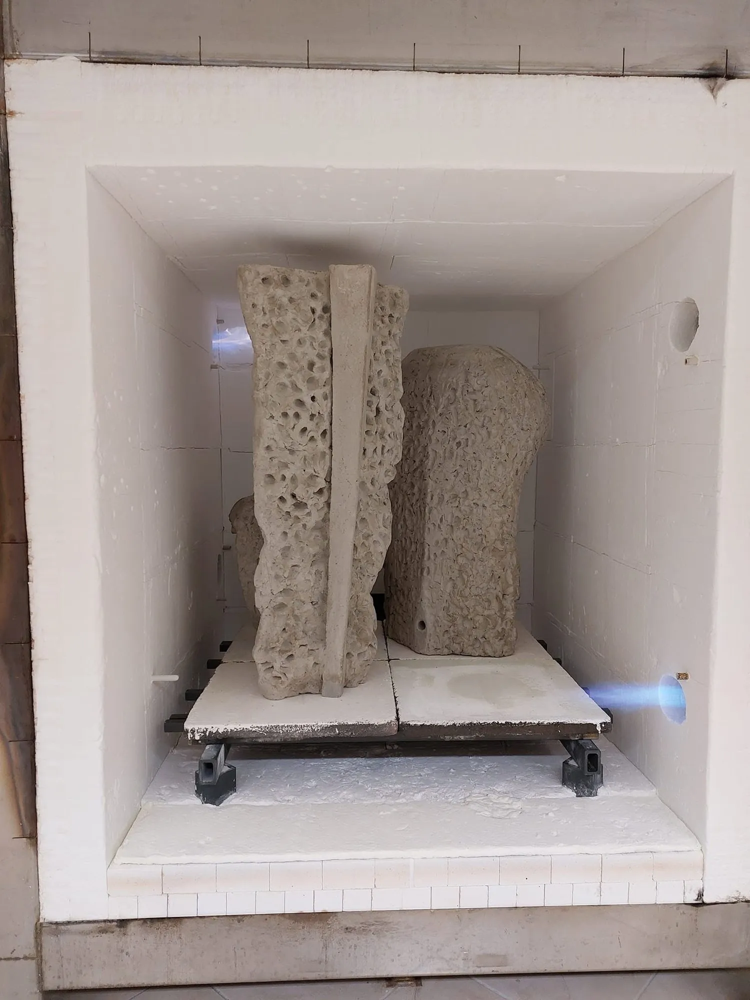 Open ceramic kiln with two large sculptures inside
