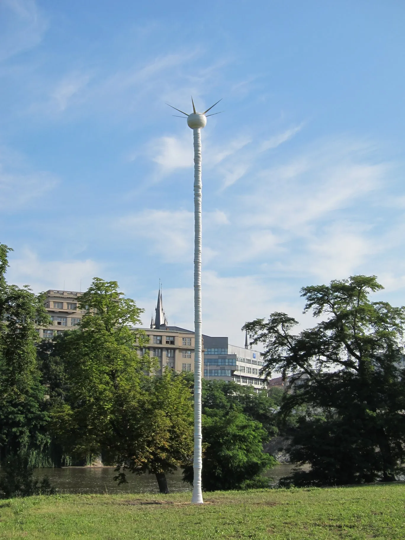 White column with a radiating crown in a riverside park by day