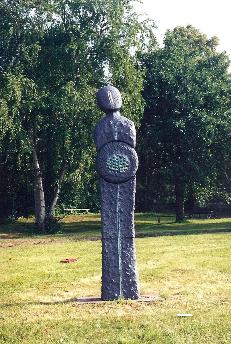 Dark figure with a circular relief on the chest in a park