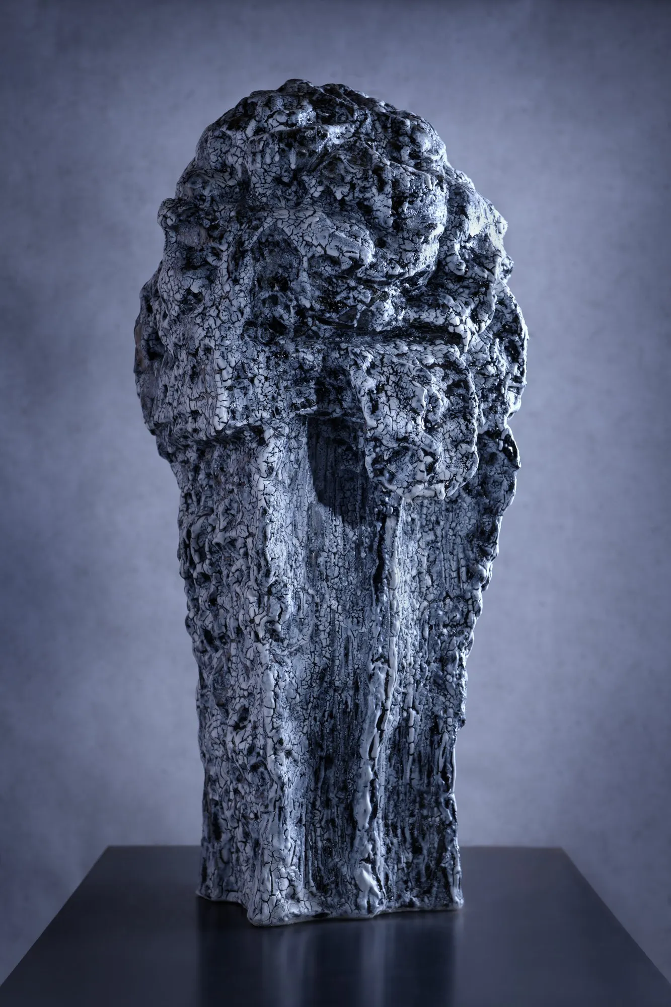 Prismatic figure with a disrupted surface and blue and white glaze