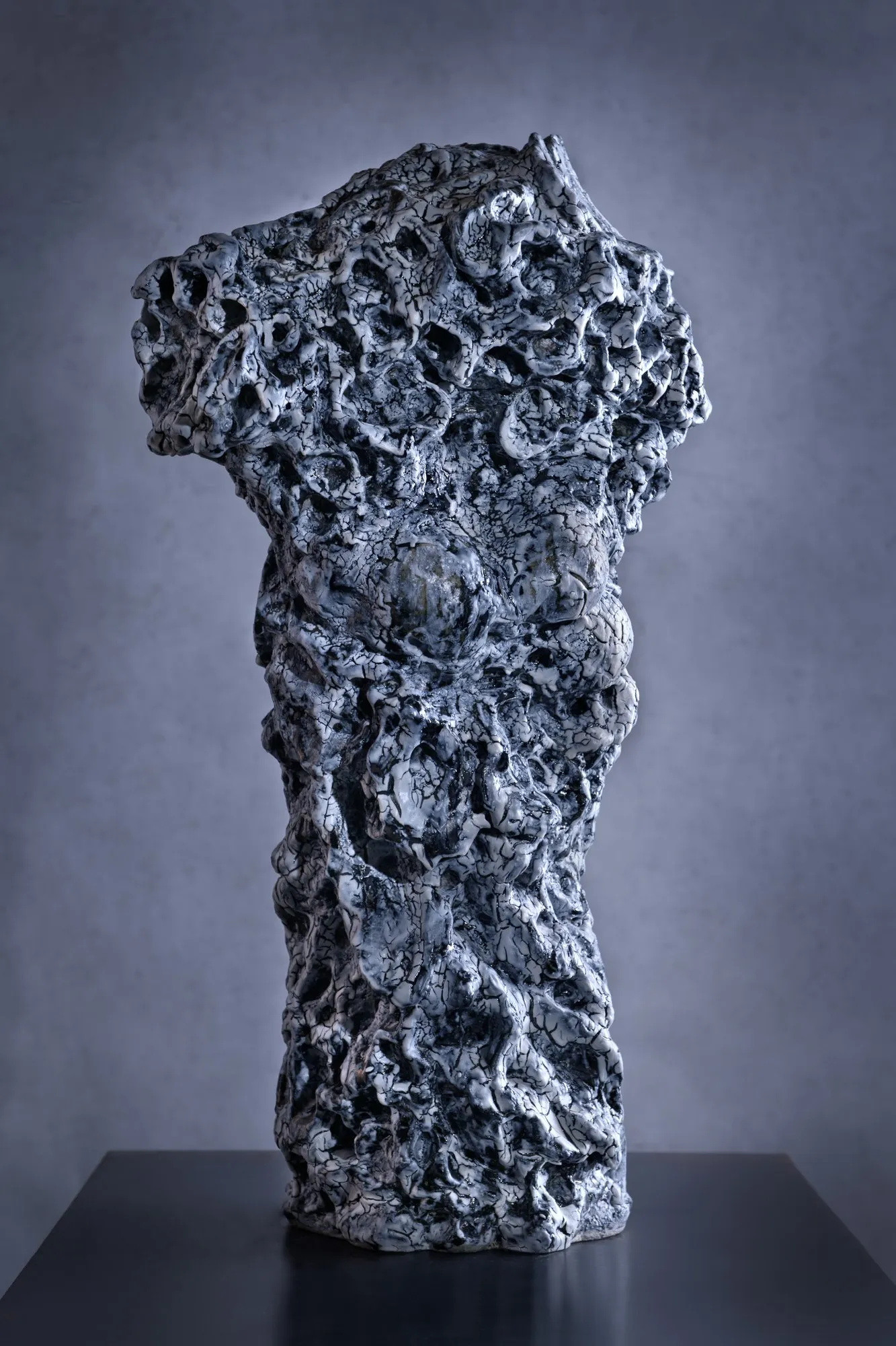 Figure widening at the top with a porous blue and white surface