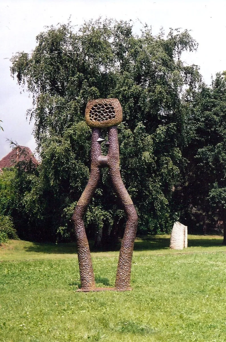 Brown figure with legs apart forming a gate