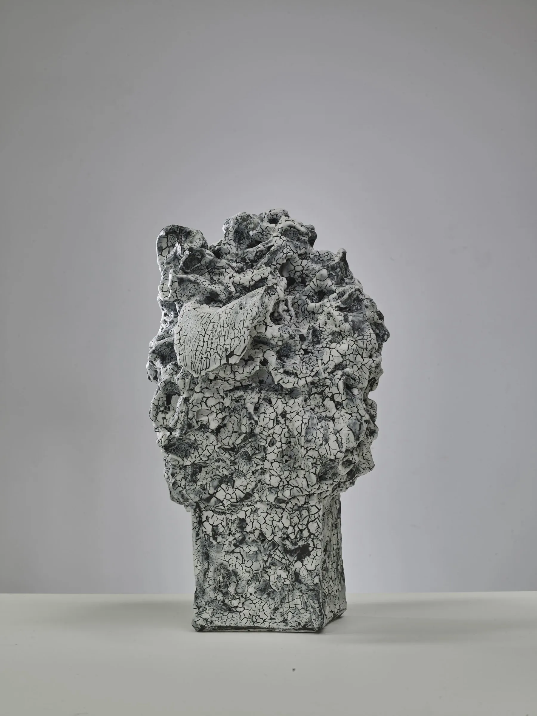 Porous sculpture with the imprint of a face in its broken surface