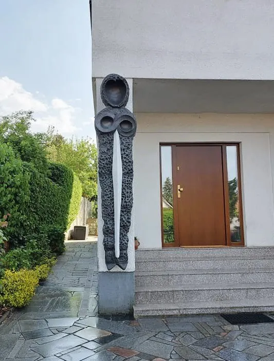 The dark Guardian sculpture in front of the entrance, seen from the pavement